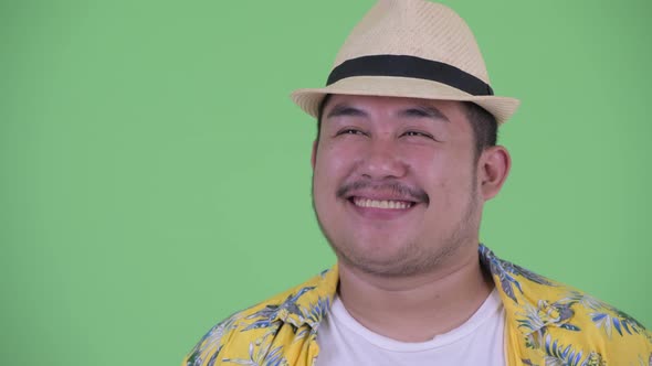 Face of Happy Young Overweight Asian Tourist Man Thinking