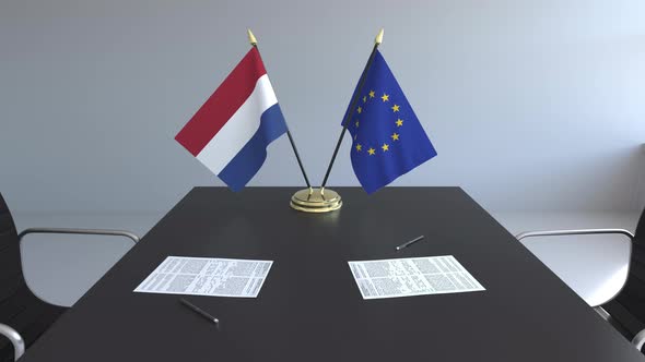 Flags of Netherlands and the EU and Papers on the Table alt
