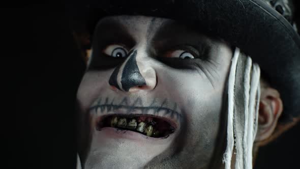 Man with Skeleton Makeup Trying To Scare, Opening His Mouth and Showing Dirty Black Teeth and Tongue