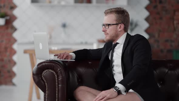 Serious Businessman Has Video Call on Laptop. He Scroll Internet of Text Document Page. Concentrated