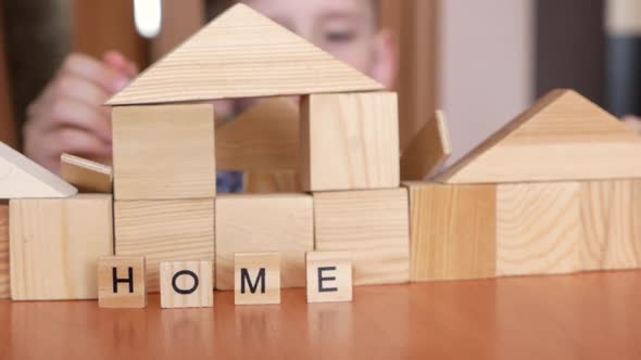 Caucasian preschooler builds a house from cubes.