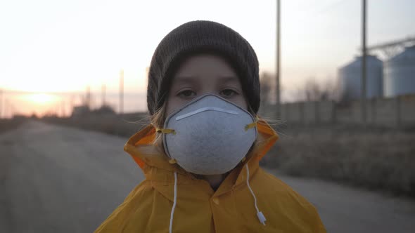 Atmospheric Pollution and People Health Concept. Child Girl in Protective Mask on Industrial Plant