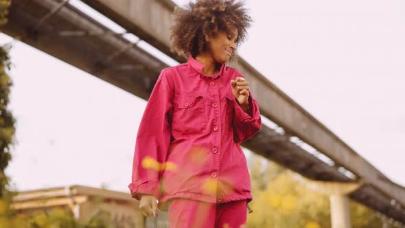 Young Woman With Afro Hair Dancing In Pink Clothes With Eyes Closed