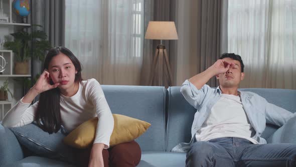 Young Asian Couple Are Watching Tv At Home With Sad Faces. Human Emotions And Television Concept