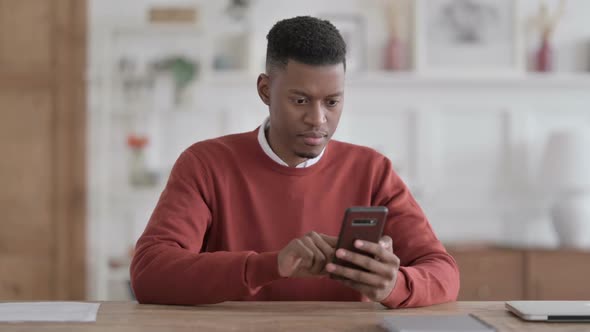 Upset African Man Reacting to Loss on Smartphone