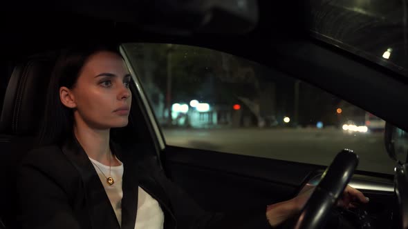 Focused Elegant Woman Driving Car at Night