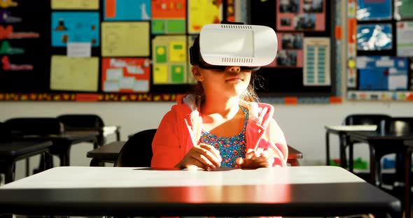 Schoolgirl using virtual reality headset in classroom 4k