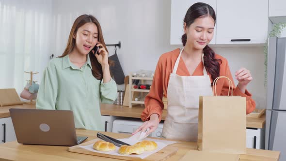 Asian beautiful business woman and friend feel happy and exciting to bake bakery and sale in house.