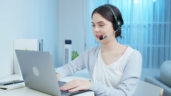 Asian young business woman call center wear headset talk to customer working at home in night time.