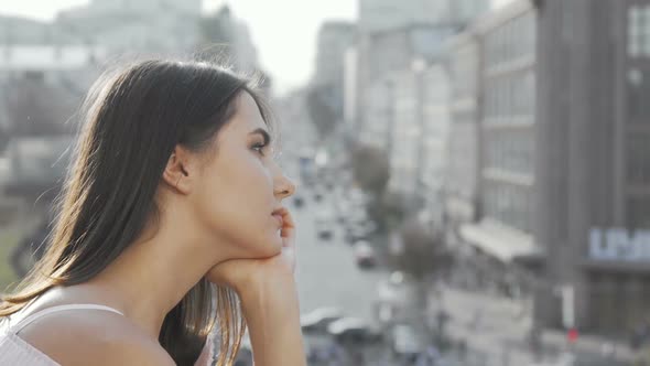 Sad Woman Looking Away at Blurry City Streets
