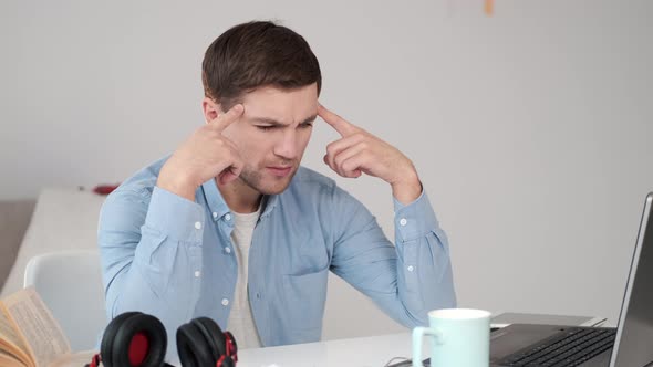 Handsome Young Man in Casual Shirt Thinking About Idea at Home Workplace