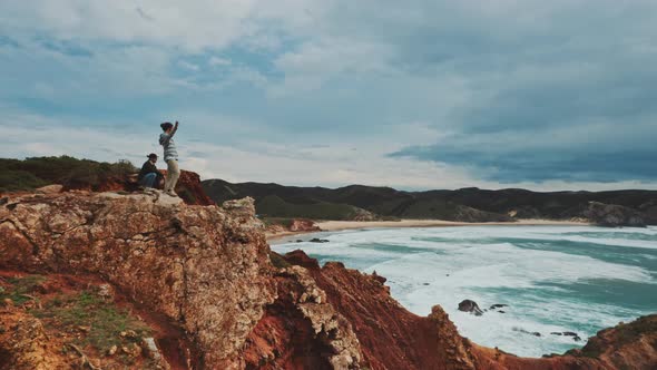 Two men on top of the coastal cliffs shot by drone