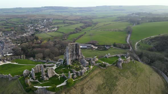 Corfe Castle ruins and surrounding rural landscape, county Dorset in England of United Kingdom. Aeri