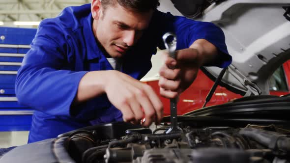 Male mechanic servicing a car