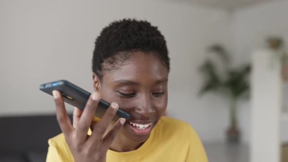 Young African American Woman Recording Audio Message on Mobile Phone at Home