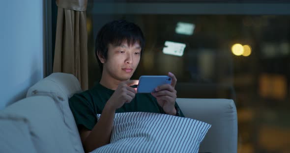 Man Use of Mobile Phone and Sit on Sofa at Night