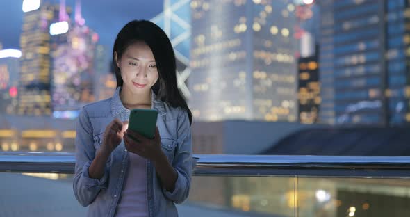 Young woman looking at mobile phone at night