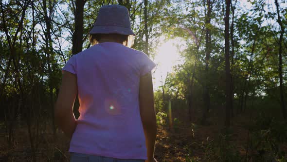 Tracking Shot of the Child Girl in Search of Adventure in the Forest Discovers the Surrounding World