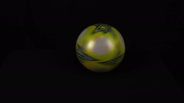Spinning Plastic Ball in front of Black Background