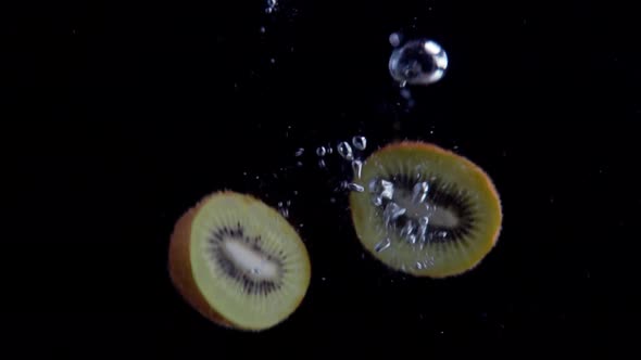 Kiwi Falling into Water Super Slowmotion, Black Background, lots of Air Bubbles, 4k240fps