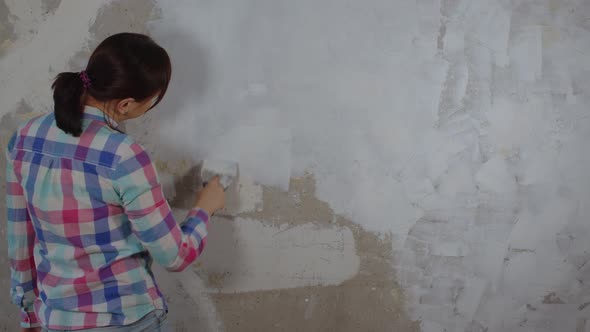 Rear View of Unrecognizable Person Applying Putty on Wall in Room