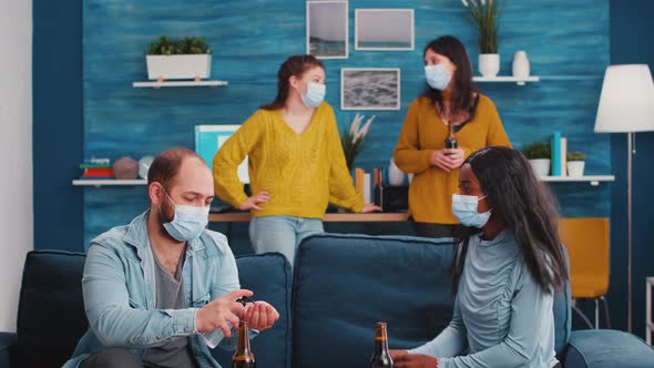 Group of Diverse Friends Using Hand Sanitizer Gel and Protective Masks