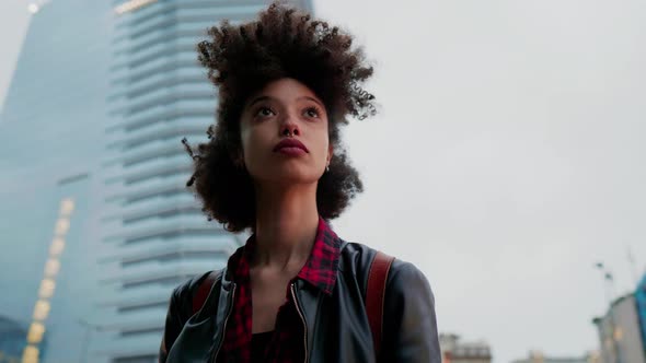 Young woman standing in the city, looking at distance