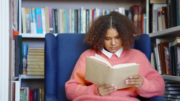 Black Girl Reading Book in Library