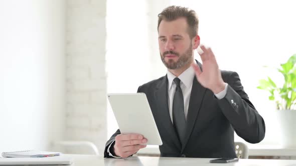 Young Businessman Making Video Call on Tablet in Office