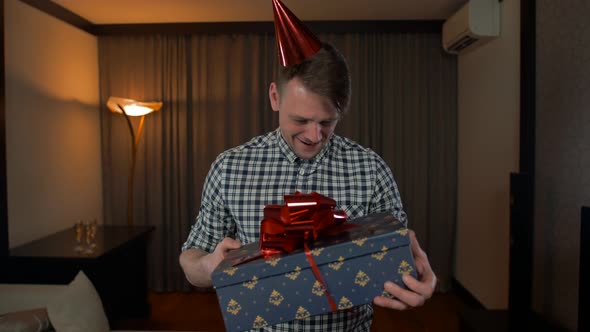 POV Attractive Male Getting Birthday Present Box with Big Red Bow in Cozy House Living Room