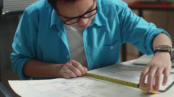 Close Up Of Asian Man Engineer With A Laptop Measuring Blueprint At The Office alt