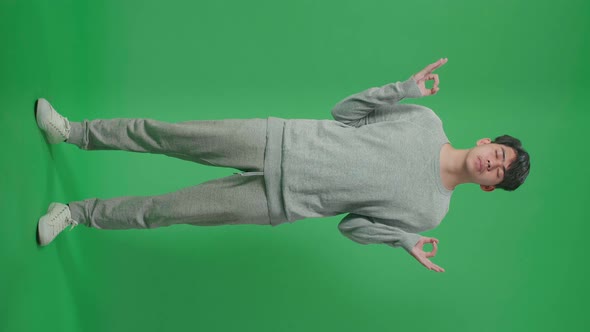 Full Body Of Asian Man Concentrate In Front Of Green Screen Background