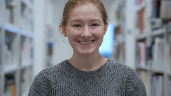 Portrait of Smiling Young Woman Looking at Camera in Cafe