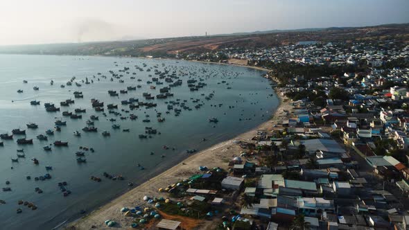 Numerous Boats Moored Offshore In A Crowded Fishing Village During Sunset In Mui Ne, Southern Vietna