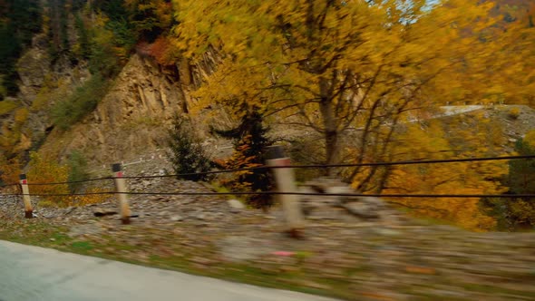 camera shoots from first person, car is driving along a narrow mountain road.