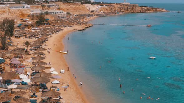 Tropical Beach with Sun Umbrellas on Red Sea Near Coral Reef