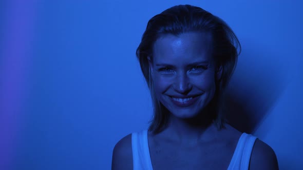 Beautiful Model in Front of Wall Laughing While Inside Dark Room