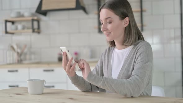 Young Woman Using and Scrolling on Smartphone