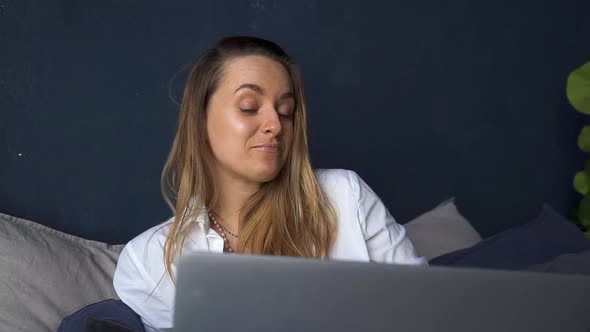 Woman Sitting on Bed and Having Video Call Via Laptop Akspb