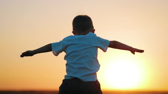 Happy Family Father and Little Son Silhouettes Playing on Meadow