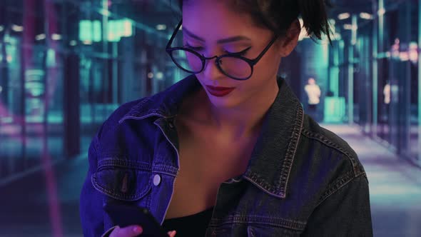 Woman Using a Smartphone in the City at Night