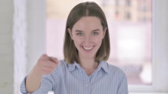 Portrait of Cheerful Young Woman Pointing Finger at Camera