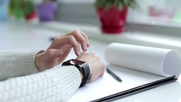 Office worker checks SMS messages on a smart watch.