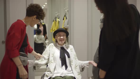 Woman in Wheelchair Trying on Cardigan at Clothing Store