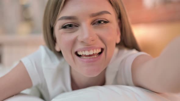 Close Up of Cheerful Young Woman Doing Video Chat in Bed 