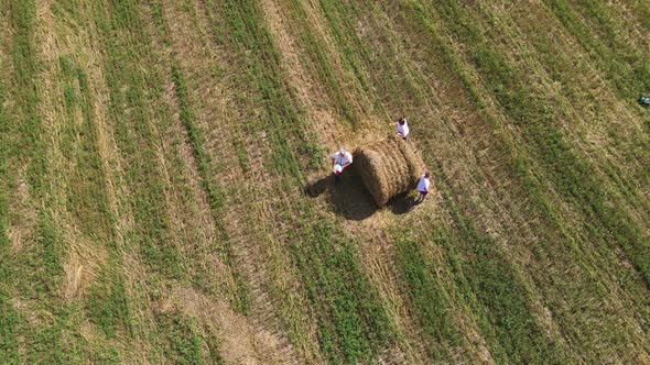 Aerial View of a Funny Family Running Around a Haystack