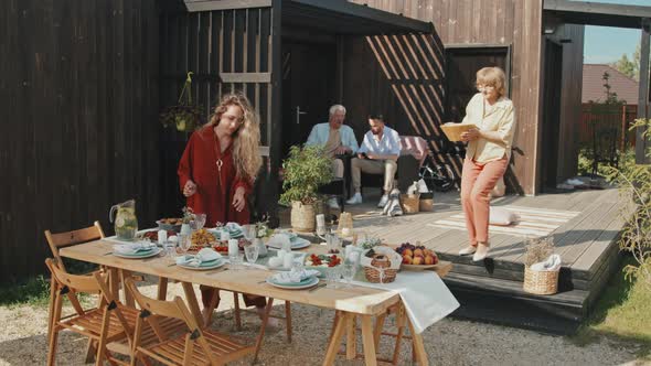 Two Women Serving Table Outdoors