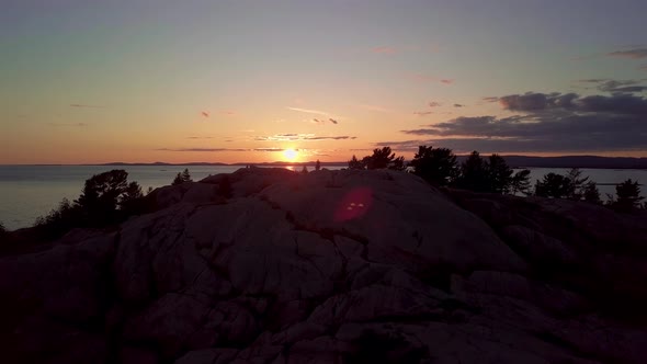 Inukshuk on Peak of Rocky Pine Tree Island at Sunset, Drone Aerial Wide Orbit Pan. Blue Lake, Colorf