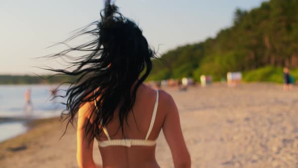 Young Woman in Bikini Swimsuit Running on Beach