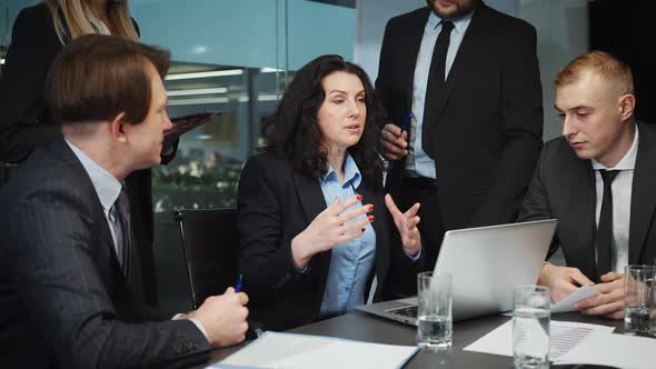 Female Leader Talking to Team at Business Meeting